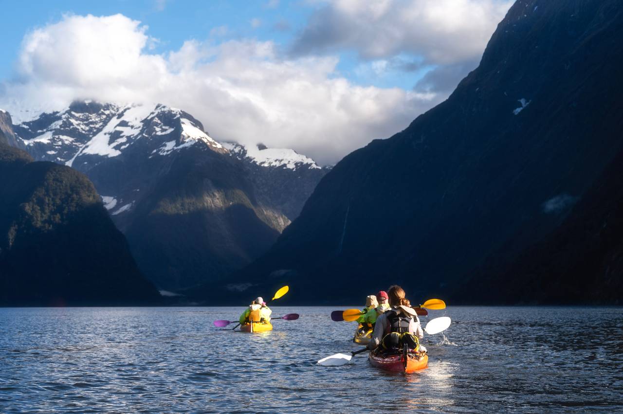 Tourists kayaking in Milford Sound, Fiordland National Park, New Zealand.